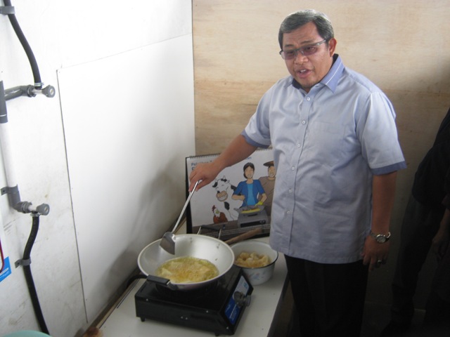 Governor of West Java, Ahmad Heryawan, cooks using the BIRU stove in Kampung Areang, West Java, Indonesia.