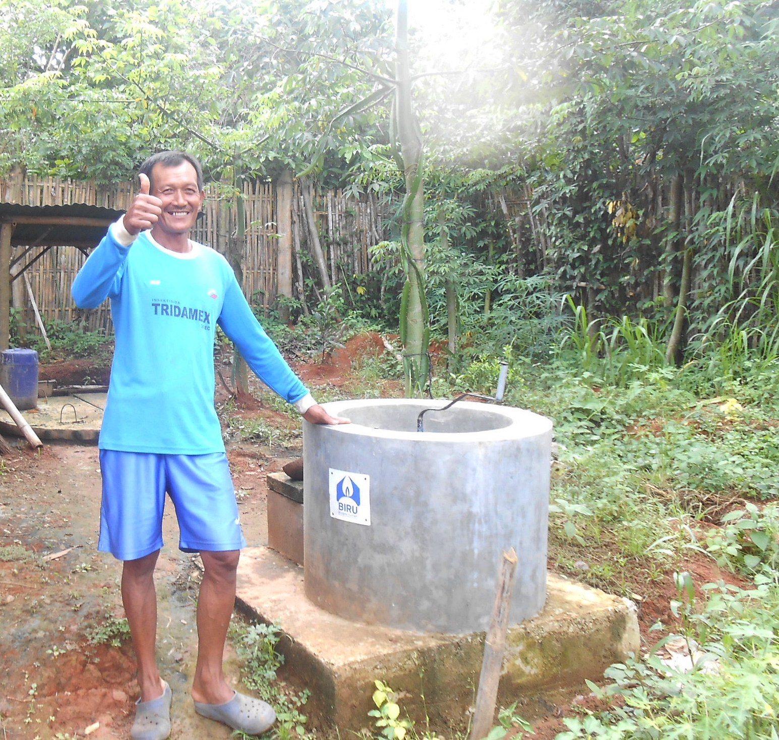 Bapak Sialim dan reaktor biogas ukuran 2 m3 miliknya (foto – Ririn Ridiarti)